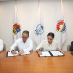 Ana Patricia Peralta firmando un documento con el Fiscal General del Estado,