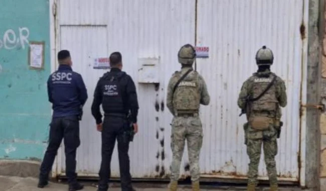 Elementos policiales frente a negocio clausurado.
